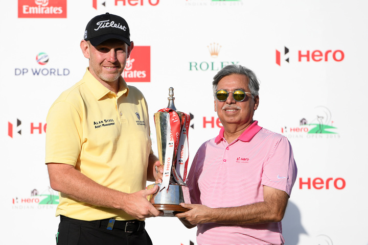 Stephen Gallacher of Scotland poses with the trophy and Pawan Munjal of HERO during the final round on day four of the Hero Indian Open at the DLF Golf & Country Club 