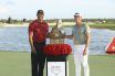 Tiger Woods handing over the winning trophy to Viktor Hovland